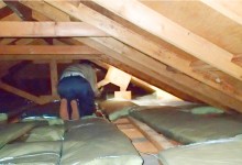 屋根裏の雨漏りを点検する作業員