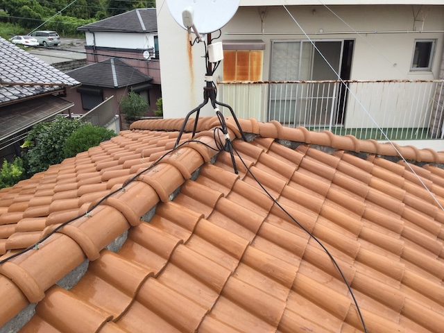 S形瓦の屋根上に設置されたBSアンテナと、サビが進行し固定が不安定なアンテナ脚