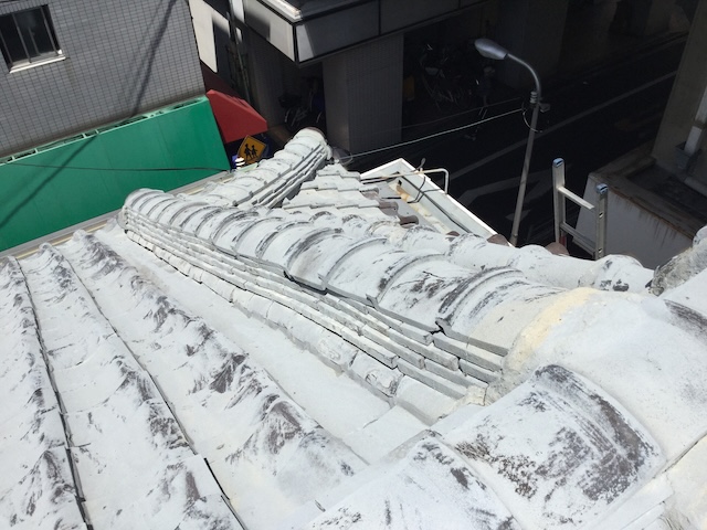 瓦表面のアップ。DIY塗装特有の刷毛ムラやダレが確認できる。瓦自体は健在だが、再塗装には不向きな下地状態。