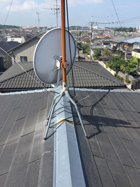 屋根上のテレビアンテナの足元が激しく赤錆びており、錆びた雨水が屋根材に流れる「もらい錆」の原因となっている状態。