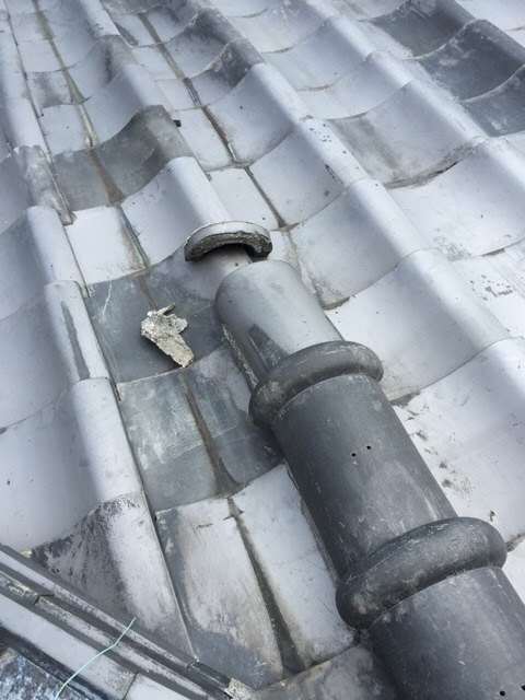 経年劣化で割れて落下した日本瓦と崩れた漆喰の破片