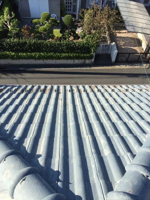 表面の防水塗膜が失われ、白く色褪せてザラザラになった古いセメント瓦の全体写真