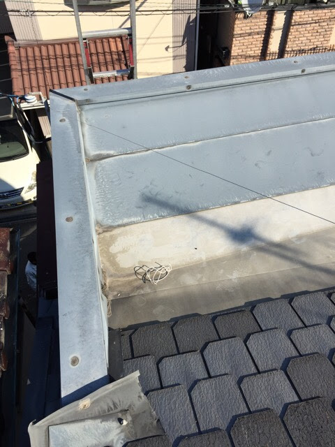  東大阪市瓢箪山での屋根調査。谷樋（つなぎ目の溝）に水が溜まりサビが発生している状況。