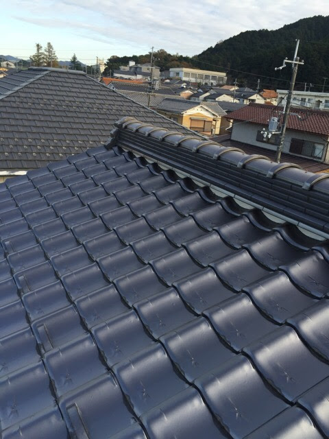 雨漏りの原因になりやすい屋根のてっぺん（棟）の瓦の積み方を確認する様子