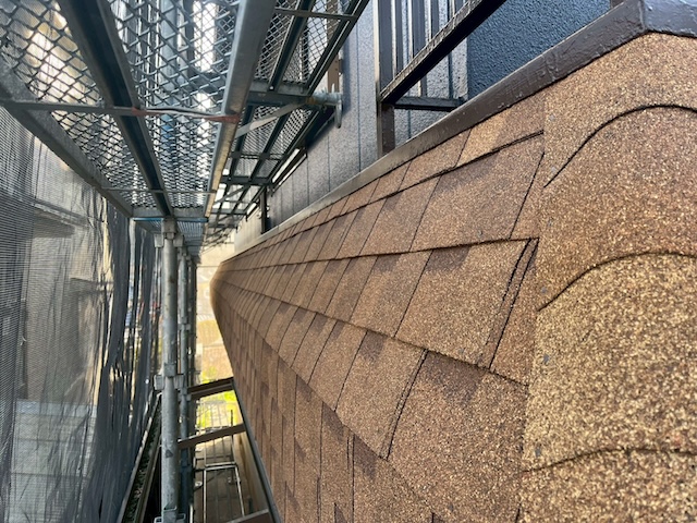 パラペット雨漏り修理の施工完了：塗装ではなくアスファルトシングル材（茶色）によるカバー工法。美観と防水性を高め、アパートの資産価値を向上させた仕上がり。