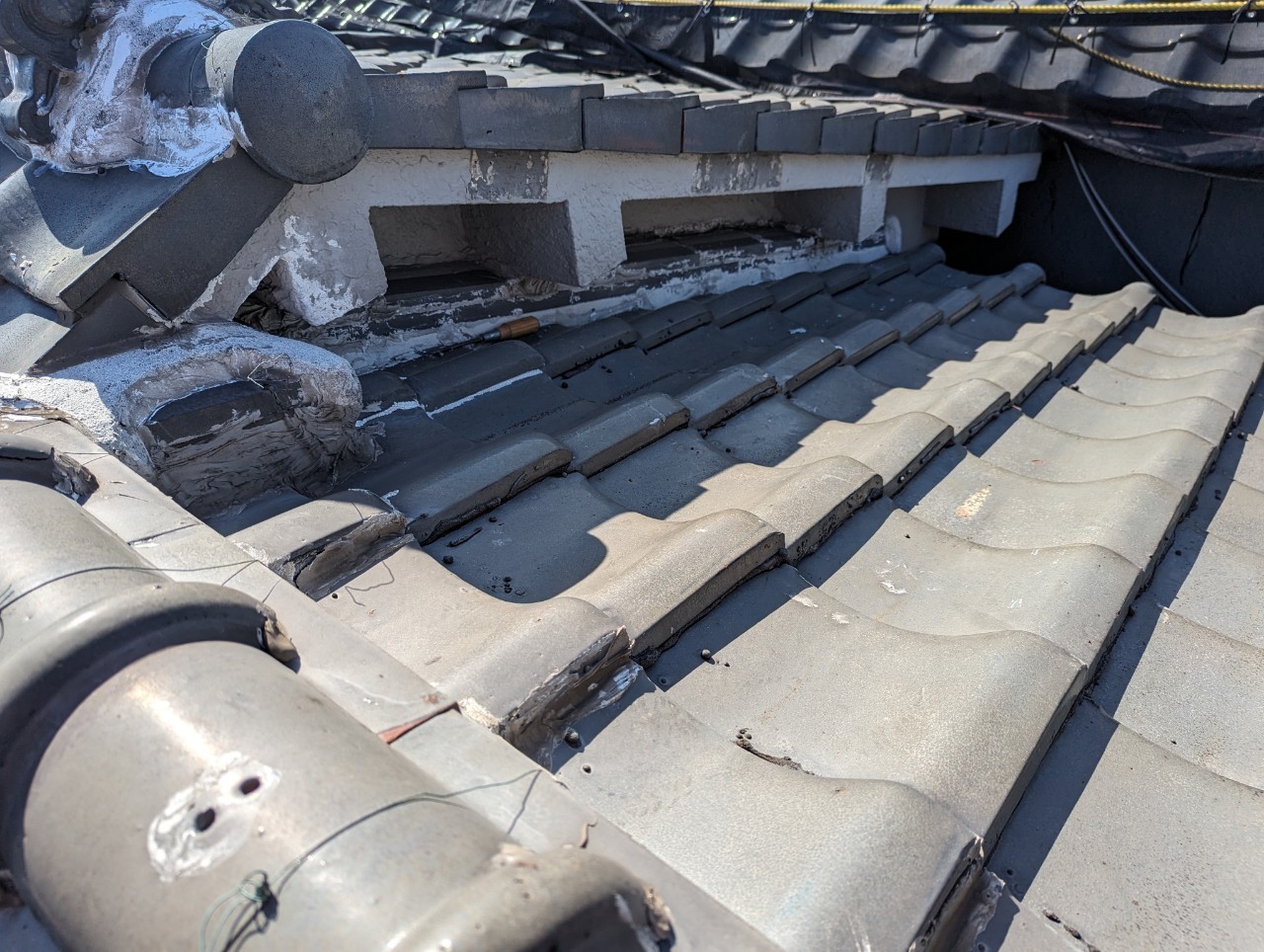 漆喰が剥がれ、瓦が浮き上がっている詳細。雨漏りや飛散のリスクが高い状態。