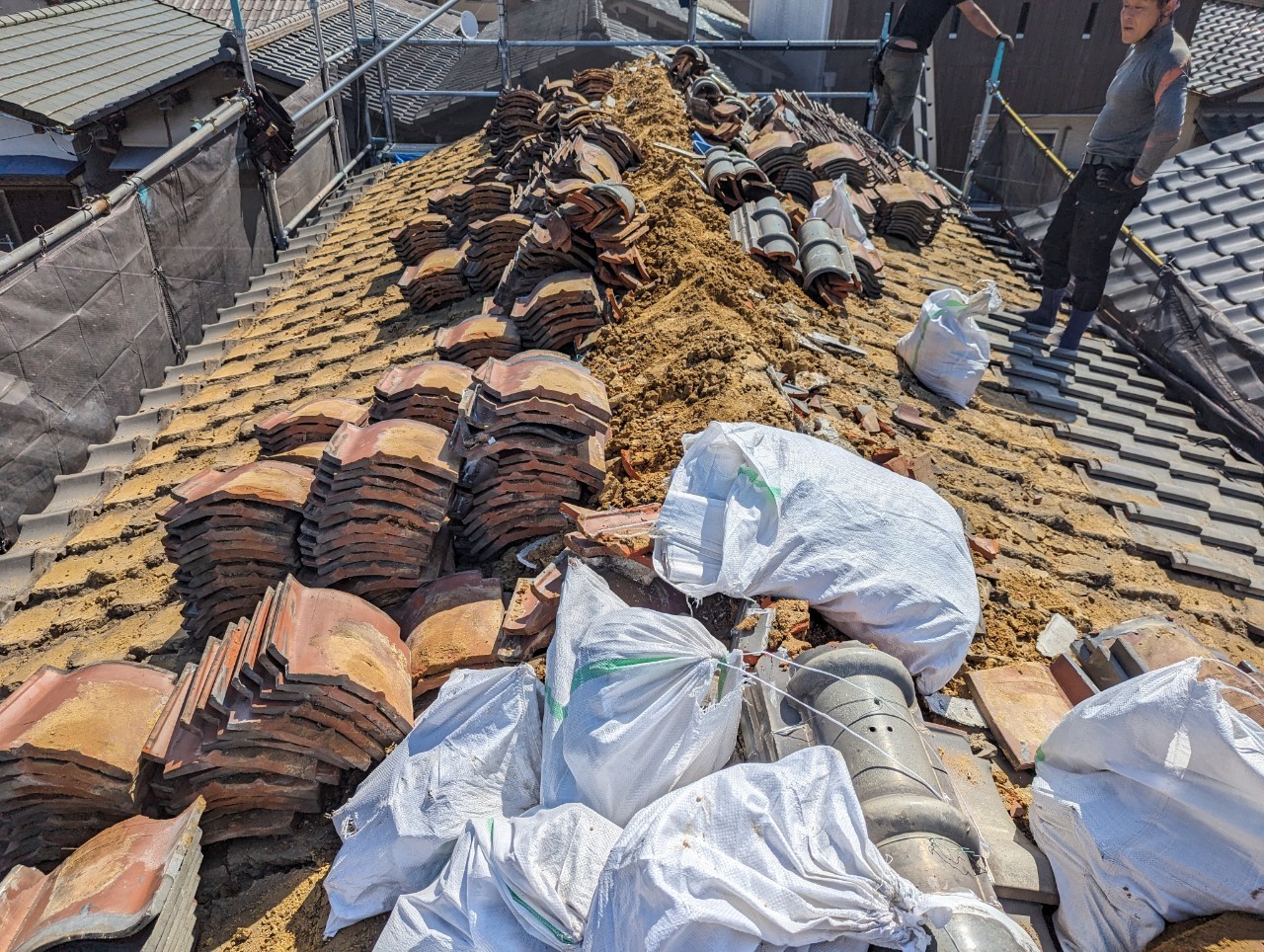 大量の葺き土と和瓦を撤去。屋根の軽量化のためには避けて通れない過酷な作業。