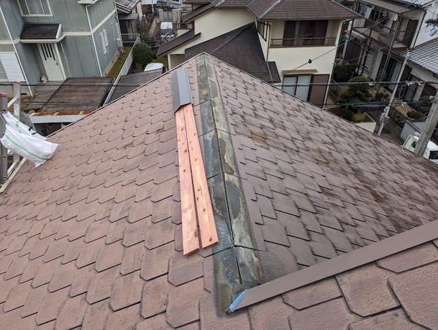 新しい貫板と棟板金を屋根上に準備し交換作業を開始する様子