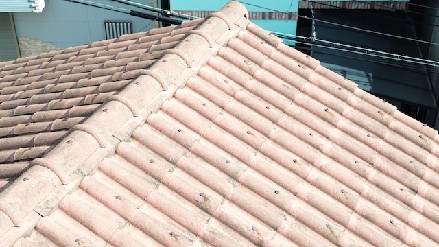 藤井寺市の現場。セメント瓦（モニエル瓦）の塗装が剥がれ、劣化が進んでいる様子