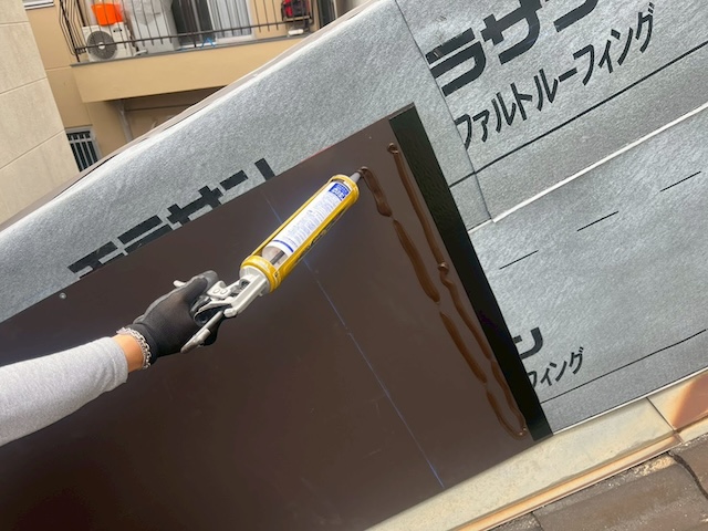 板金の裏側や重なり部分に止水用のシーリング材を塗布して防水性を高める様子