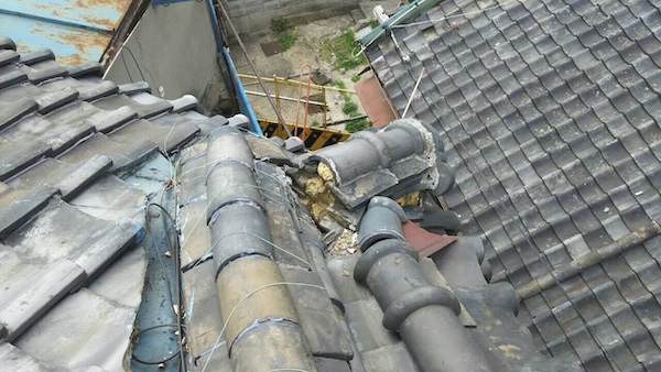 今にも落下しそうな大阪市平野区の瓦屋根。庭への土砂落下の原因箇所。