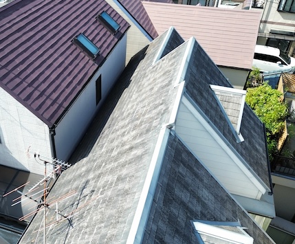 経年劣化とコケの繁茂が進むスレート屋根と大阪市福島区の住宅密集地の様子