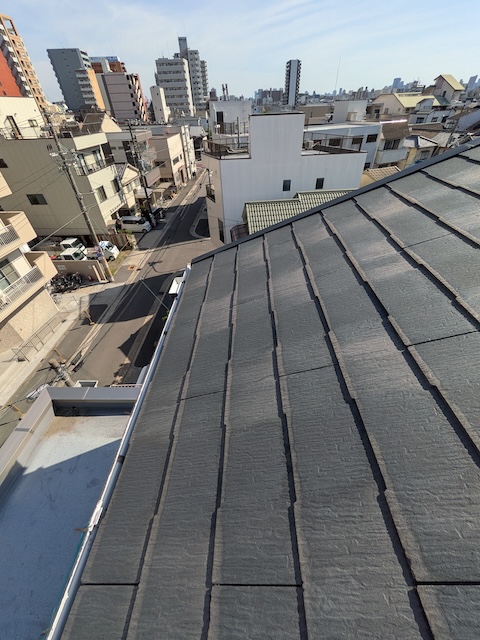大阪市生野区の街並みを背景にした施工予定の塔屋屋根
