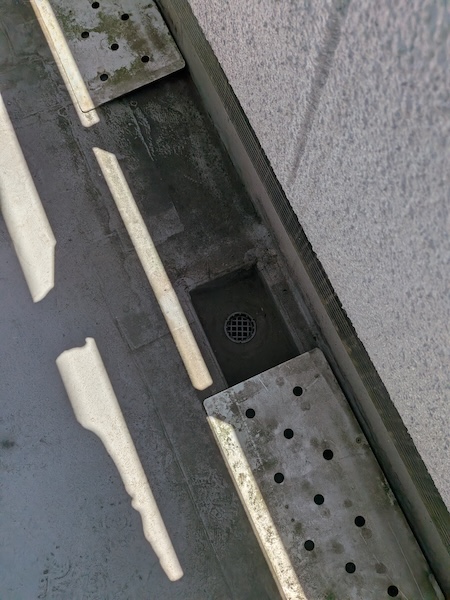 完全に土砂で詰まりかけているベランダの排水口（ドレン）部分