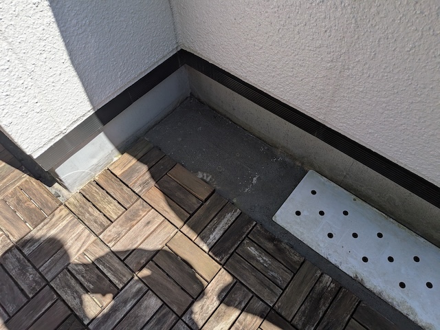 ウッドパネルを撤去した下部に蓄積した砂埃と苔
