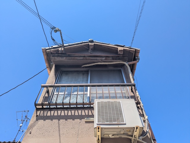 東大阪市横沼町で下地が腐食し電線に引っかかり脱落寸前になっている危険な2階庇の全体像