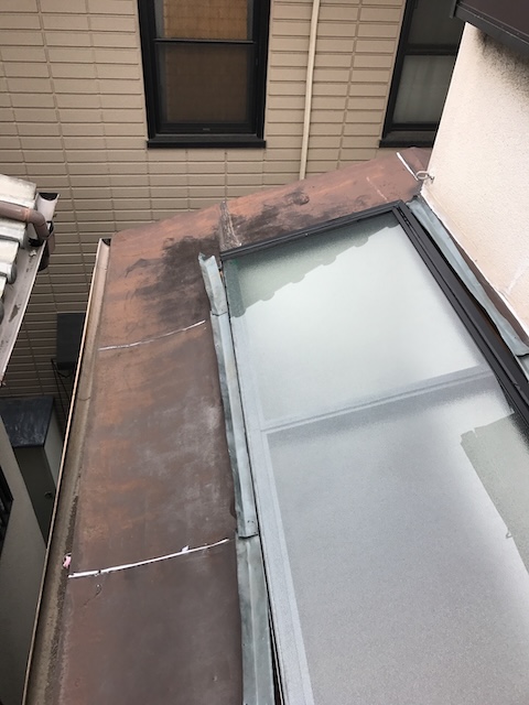 大阪市東住吉区で板金屋根補修調査、金属屋根の茶褐色の変色と継ぎ目の白い材料を点検