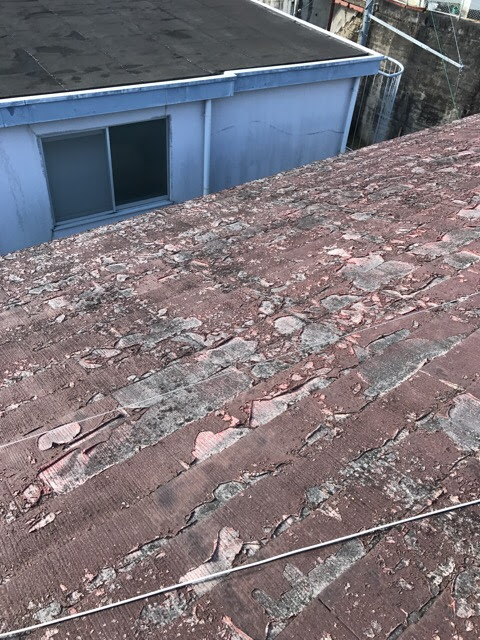 長雨による雨漏りが心配されるほど表面剥離が進んだスレート屋根