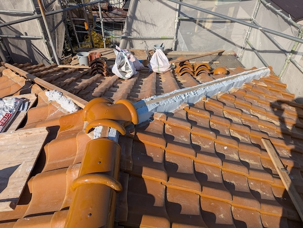 漆喰の土台の上に職人の手作業で一枚ずつ丁寧に瓦を伏せていく工程