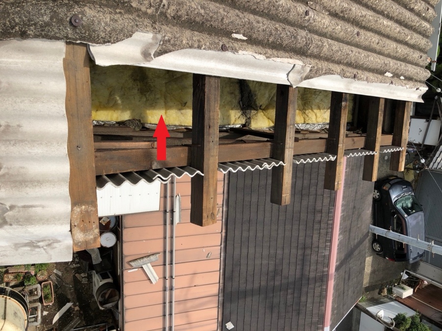 台風でスレートが吹き飛び断熱材が完全に露出してしまった工場屋根の危険な状態