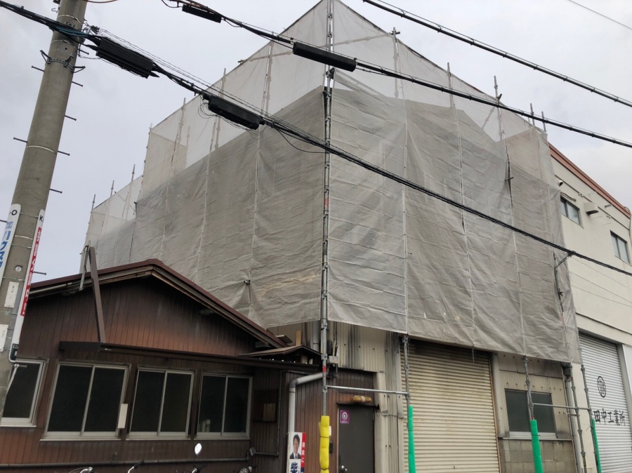 近隣への粉塵飛散を防ぎ職人の安全を守るために隙間なく設置された足場とメッシュシート