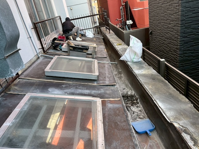 既存屋根の上に構造用合板（下地材）を敷き詰める作業工程。