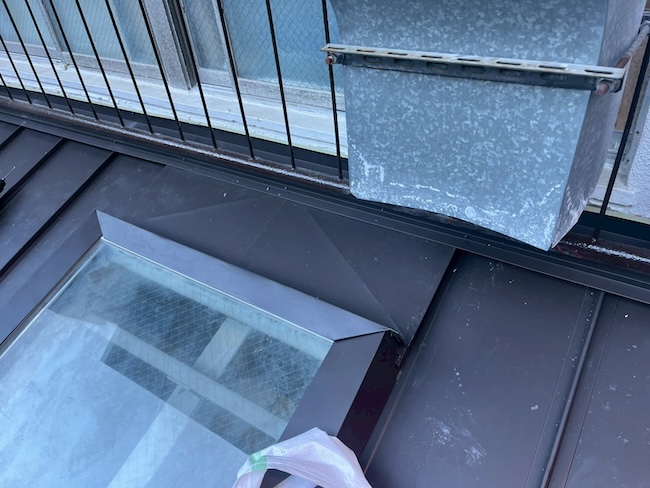 天窓の形状に合わせて現場でガルバリウム鋼板を精密に加工し、雨水の侵入を完全にシャットアウトする板金施工。